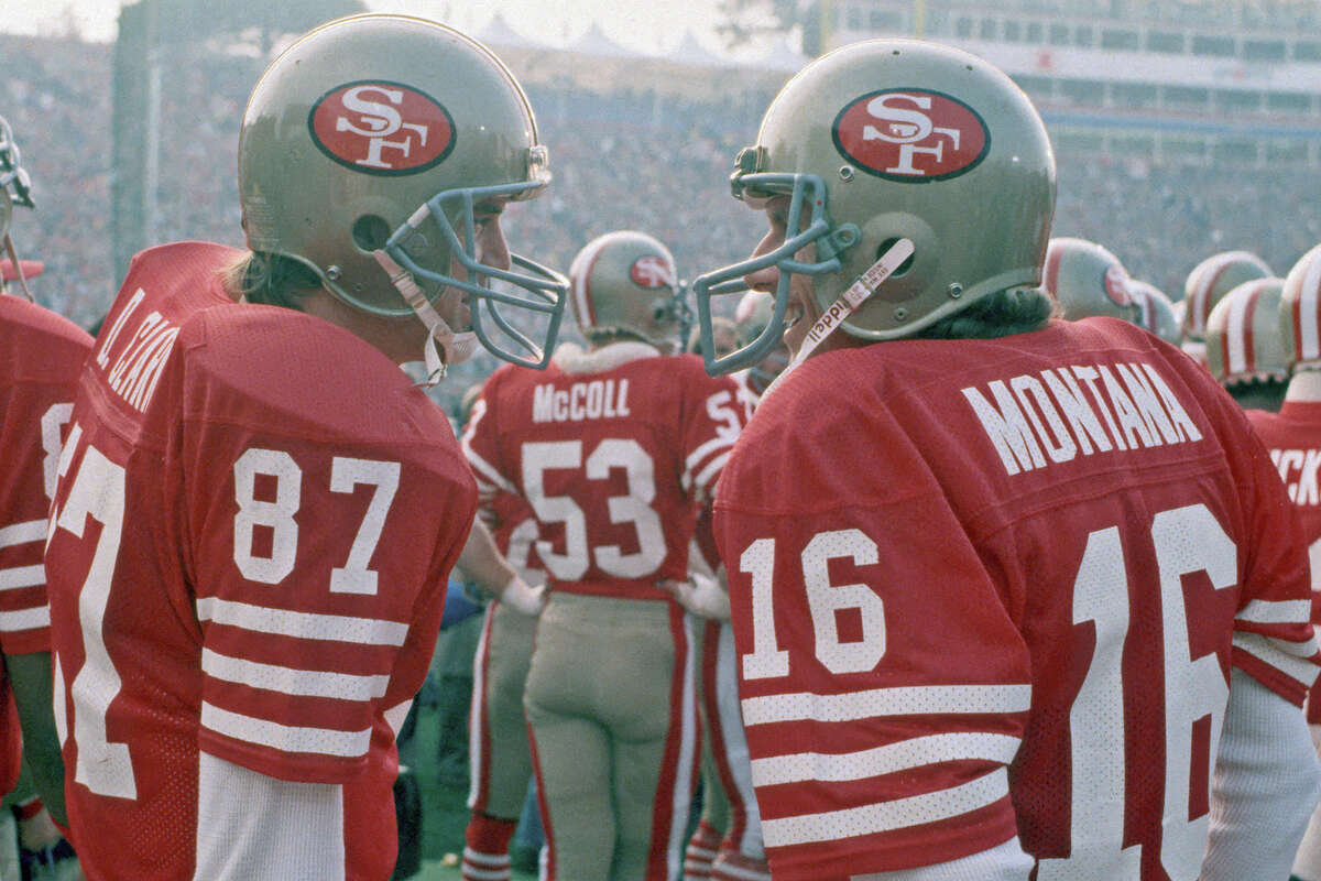 Joe Montana talks to Dwight Clark prior to player introductions before the start of Super Bowl 19 against the Miami Dolphins at Stanford Stadium on January 20, 1985. The 49ers defeated the Dolphins 38-16.