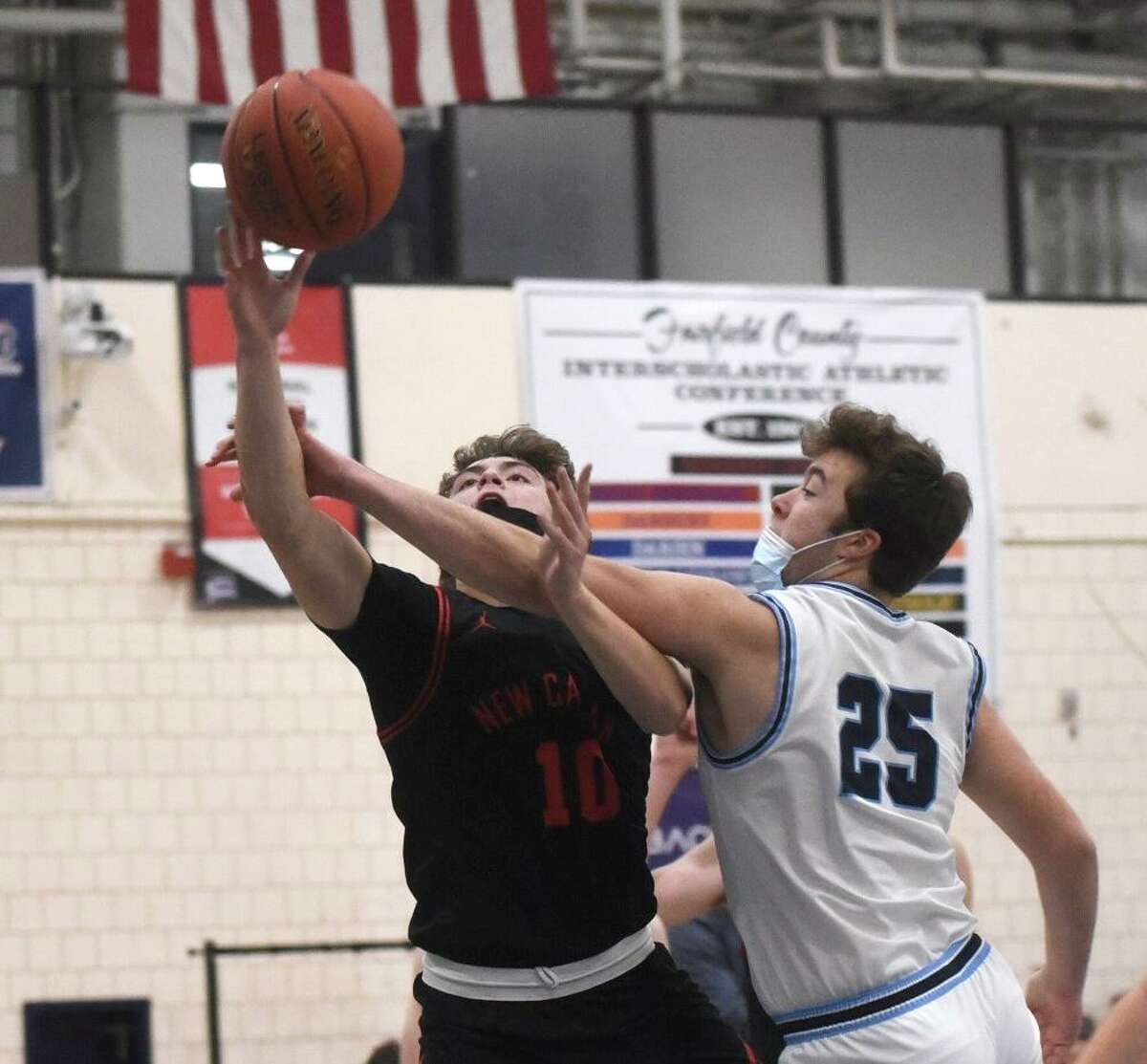New Canaan’s Ty Groff is fouled by Wilton’s Craig Hyzy on Friday, Jan. 14, 2022.