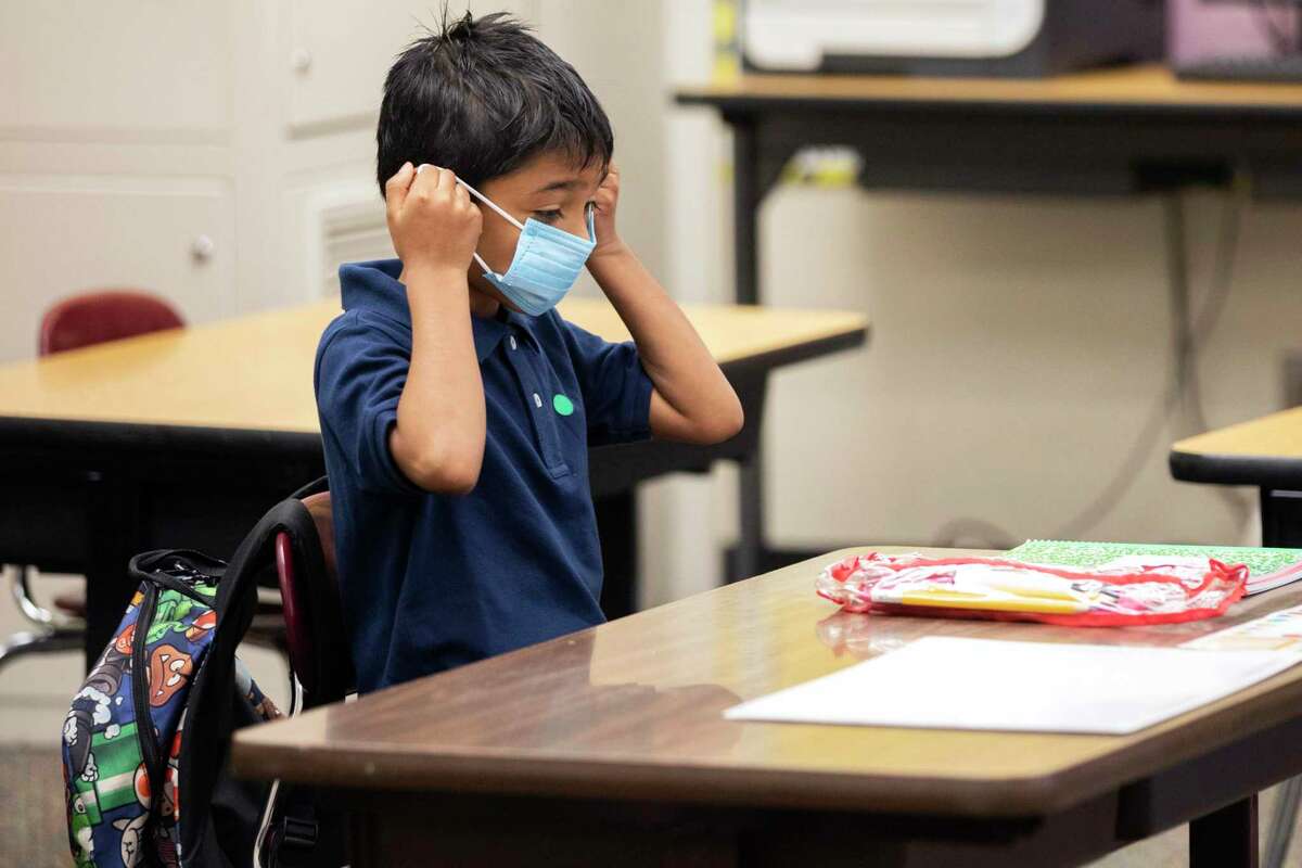 Second-grader Ernesto Beltran Pastrana puts on his mask at Garfield Elementary School in Oakland.