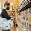 Emily Adams fills a bag with oats at Re-Up Refill Shop in Oakland.