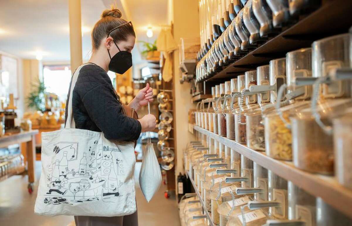 Emily Adams fills a bag with oats at Re-Up Refill Shop in Oakland.