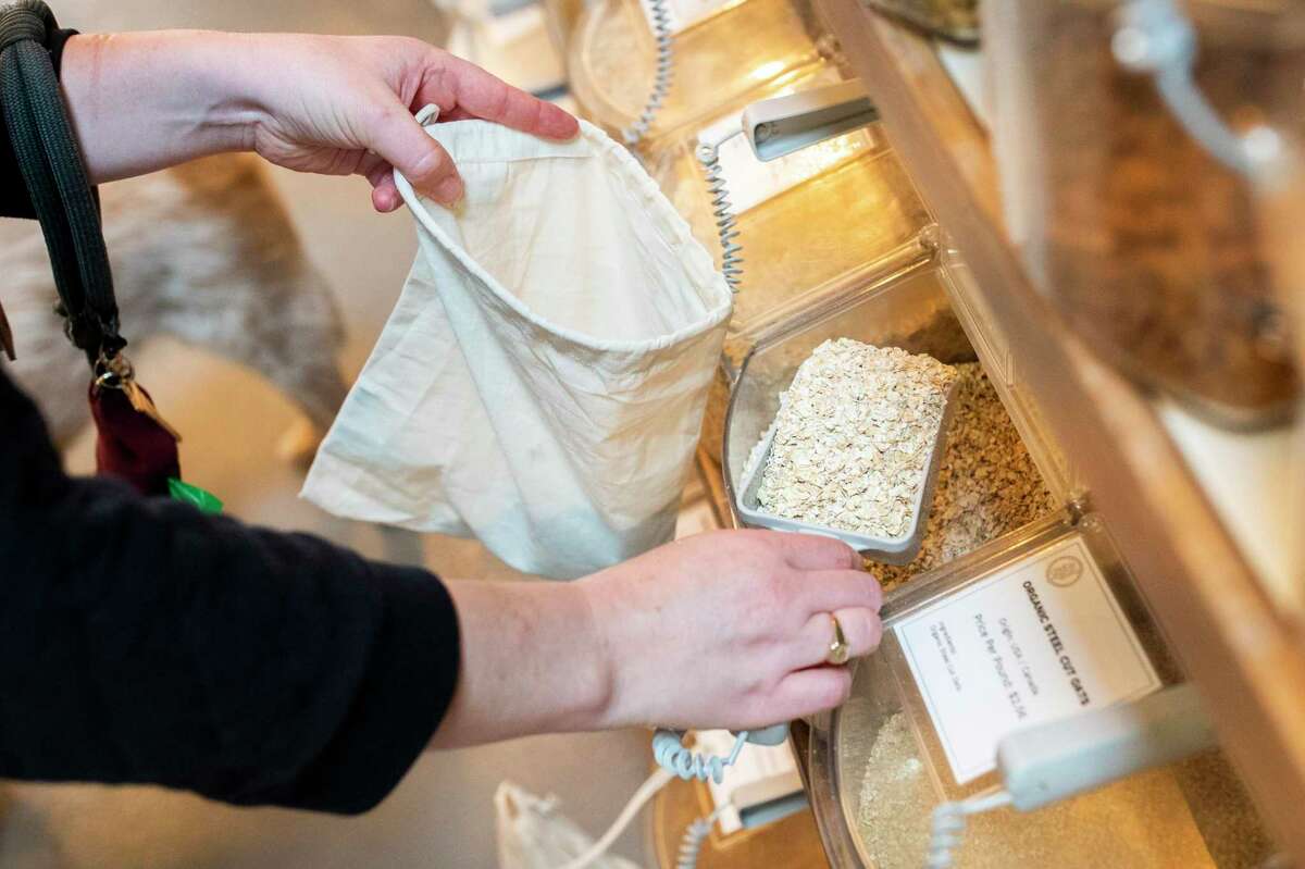 Emily Adams fills a bag with oats at Re-Up Refill Shop.