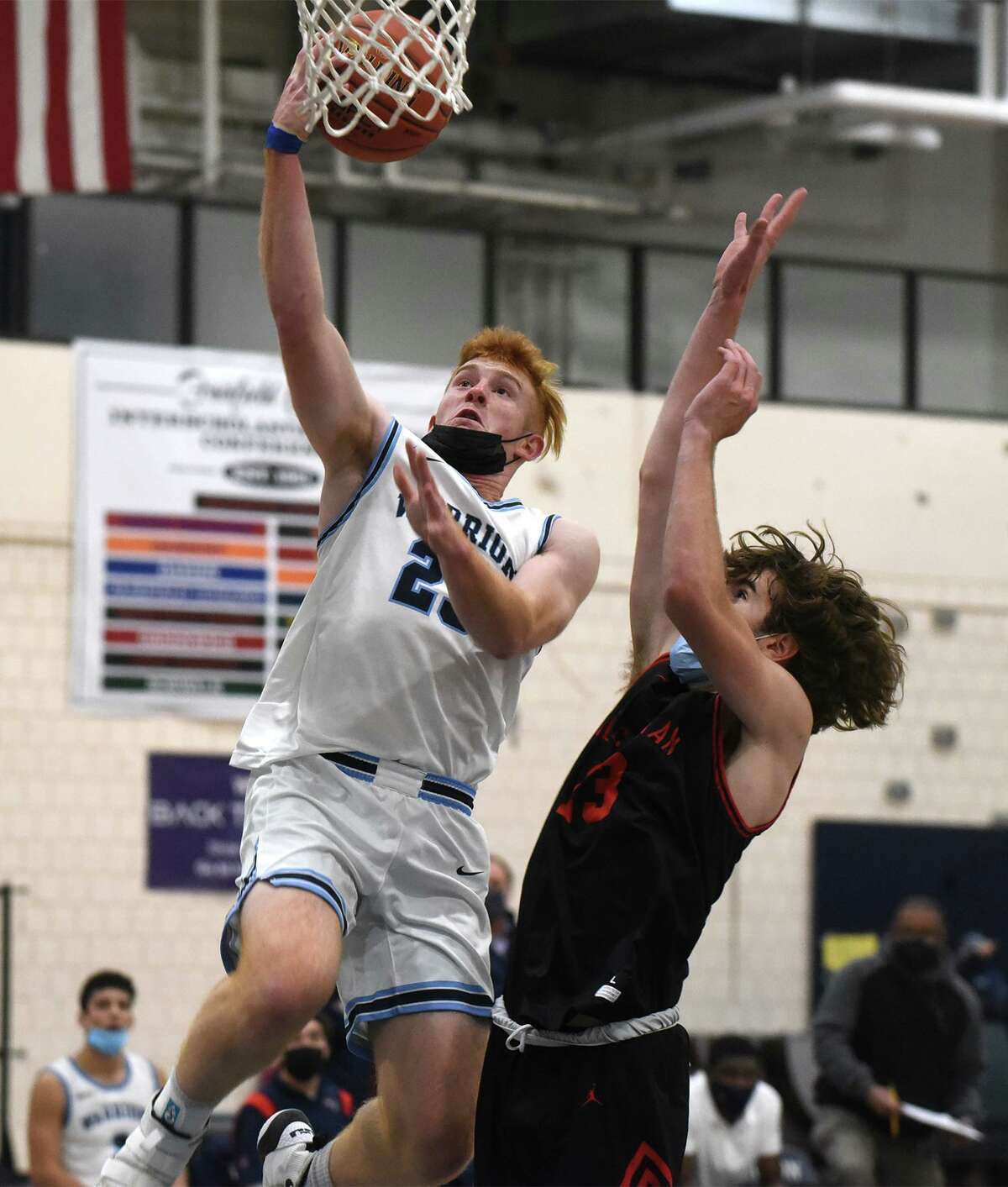 Wilton's Max Edwards (23) goes up for a shot over New Canaan's Santi Lacayo (13) during a boys basketball game in Wilton on Friday, Jan. 14, 2022.