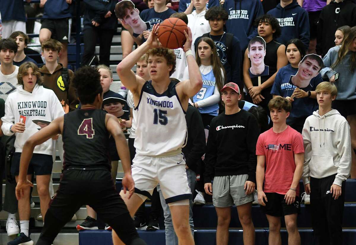 Kingwood senior Tommy Neuman (15) looks for a shot against Summer Creek senior point guard Elijah Roman (4) during the first quarter of their District 16-6A matchup at Kingwood High School on Friday, Jan. 14, 2022.