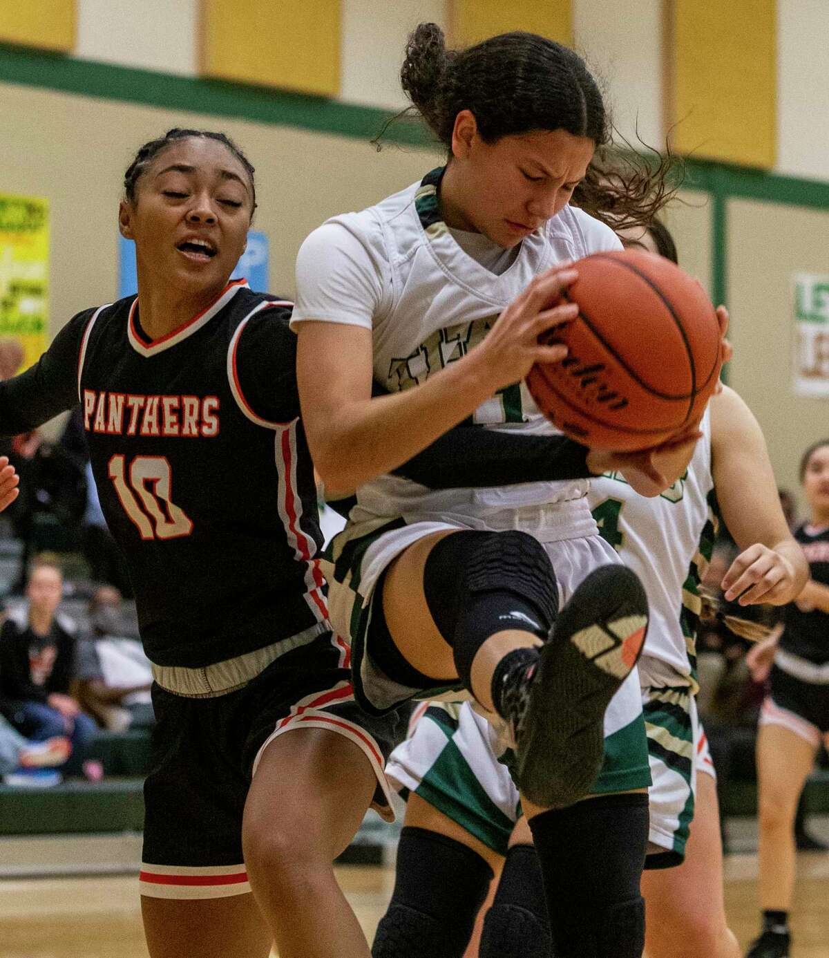 Medina Valley?•s Jaya Cosper, left, and Kera Martinez struggle Friday, Jan. 14, 2022 for ball control during the first half of the Panthers?• game against the Titans.