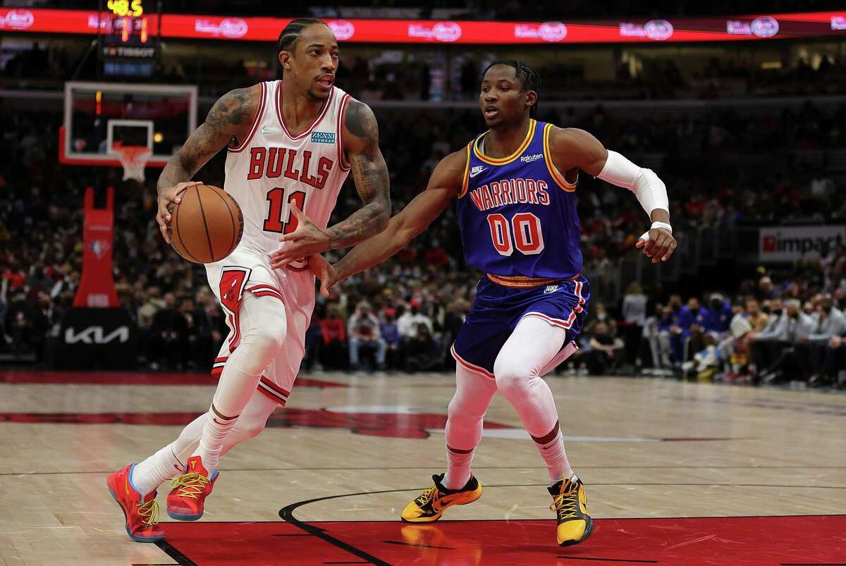 DeMar DeRozan, left, of the Chicago Bulls drives around Jonathan Kuminga of the Golden State Warriors during the first half Friday at United Center.