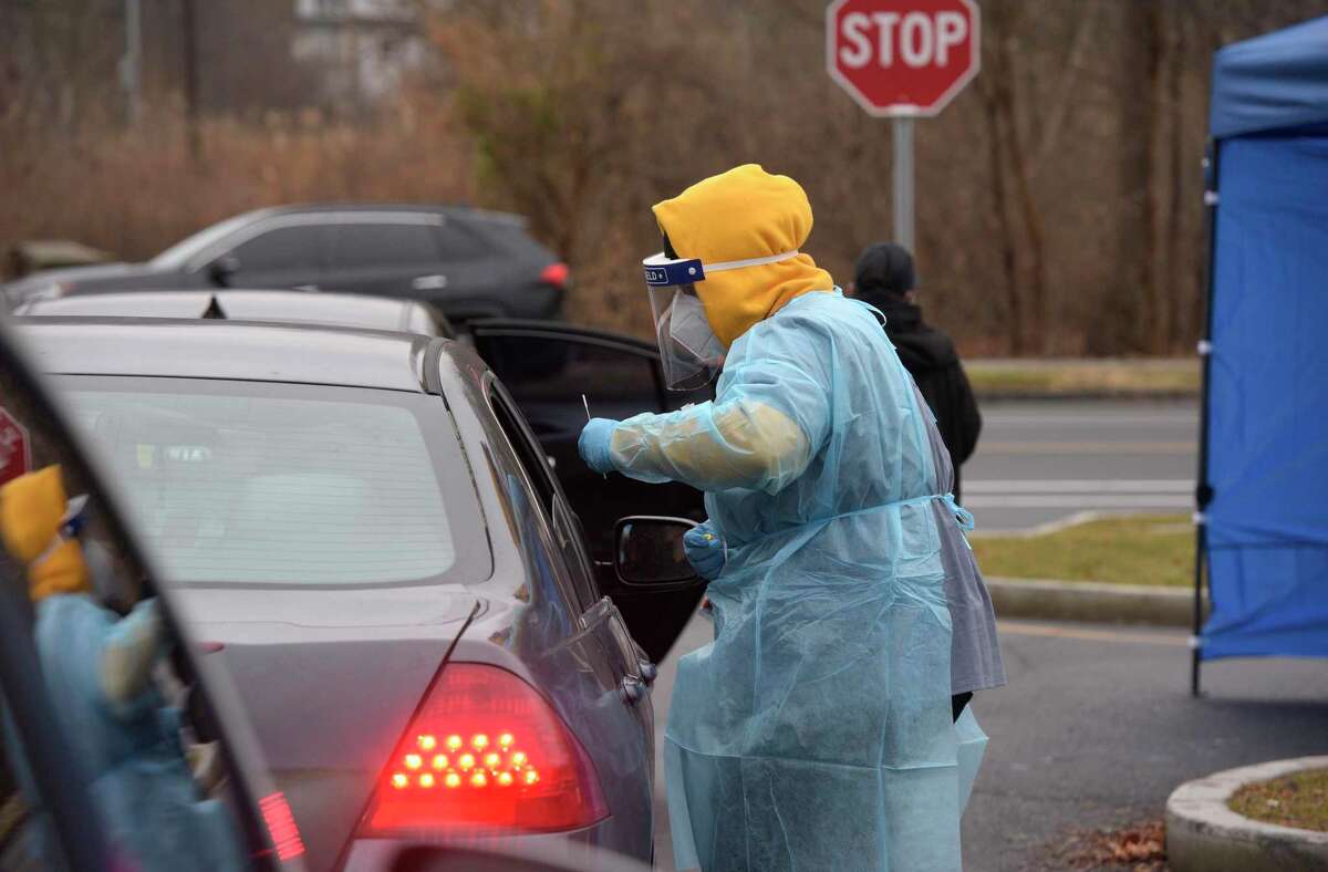 Joel Urriola administers a COVID-19 test at the SEMA4 testing site in Rogers Park in Danbury.