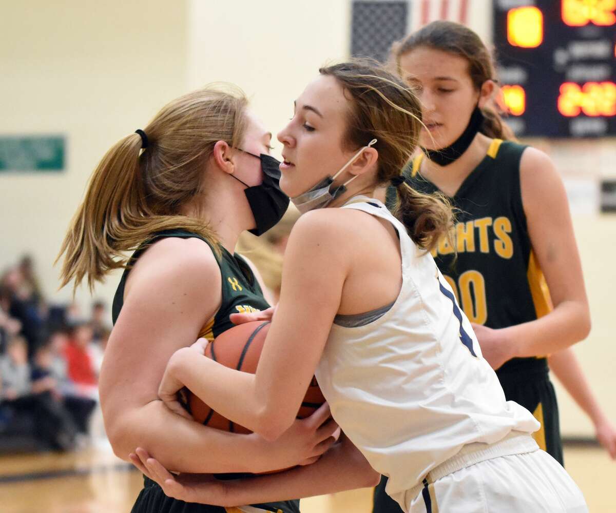 Father McGivney's Mary Harkins, right, and Metro-East Lutheran's Emma Lorenz fight for a rebound during the first half of Friday's game in Glen Carbon.