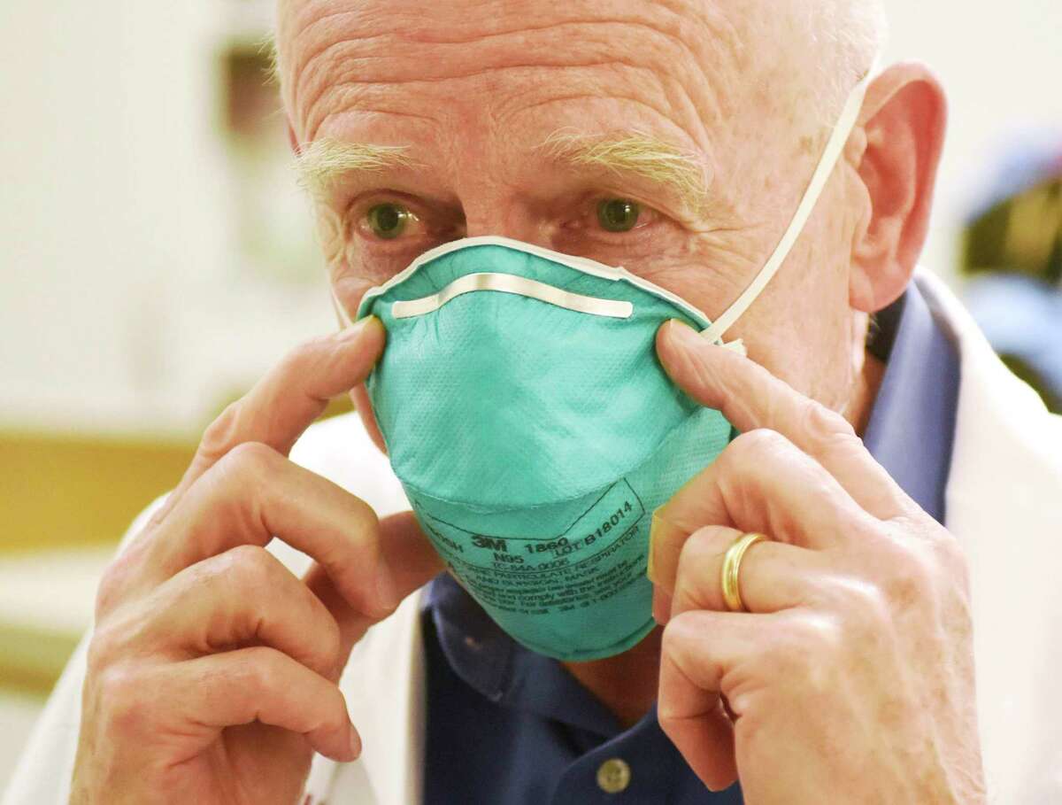 Stamford Hospital Chair of Infectious Diseases Dr. Michael Parry demonstrates an N95 medical mask while speaking about the coronavirus at Stamford Hospital in Stamford, Conn. March 4, 2020. State officials are asking schools to check whether they received recalled N95 masks.