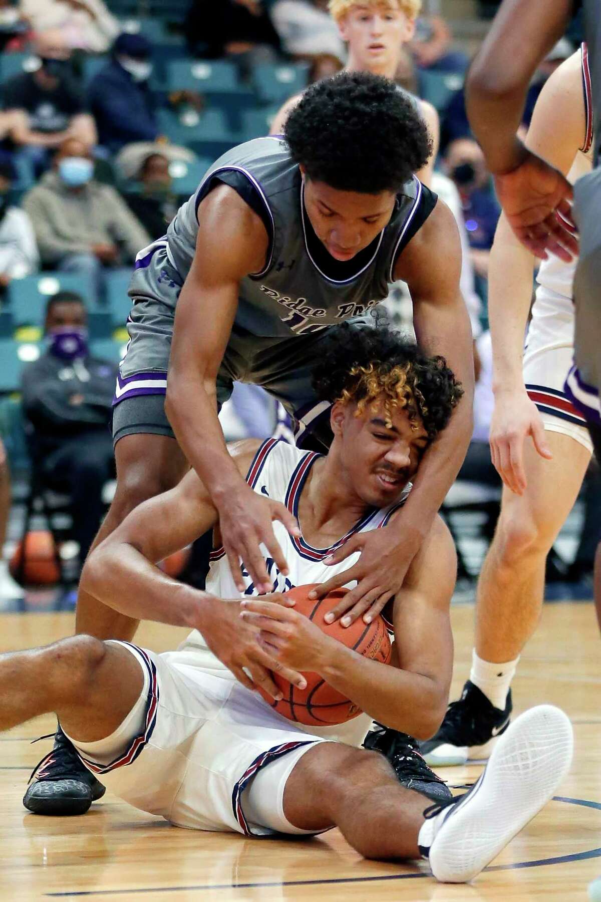 Tompkins’ B.B. Knight tries to keep the ball as Ridge Point’s Kolby Granger, top, reaches over during a Boys 6A bi-district high school basketball playoff game Saturday, Feb. 20, 2021 at the Merrell Center in Katy, TX.