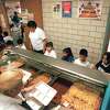 METRO ENCHILADAS - Leticia Pietro and Sylvia Lopez, food service assisstants, serve enchiladas with chili , beansand rice to a kinder garten class while Sara Trejo, cafeteria manager, guides them through the cafeteria Feb. 2, 2000.