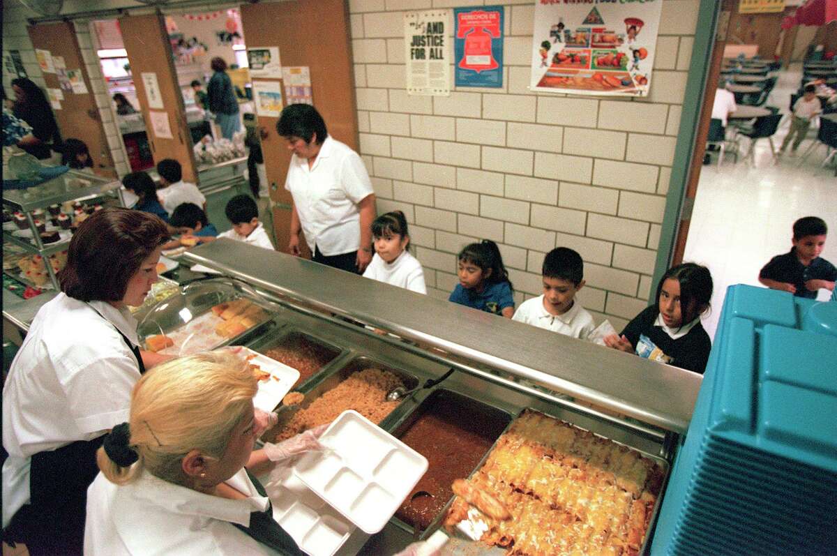 METRO ENCHILADAS - Leticia Pietro and Sylvia Lopez, food service assisstants, serve enchiladas with chili , beansand rice to a kinder garten class while Sara Trejo, cafeteria manager, guides them through the cafeteria Feb. 2, 2000.