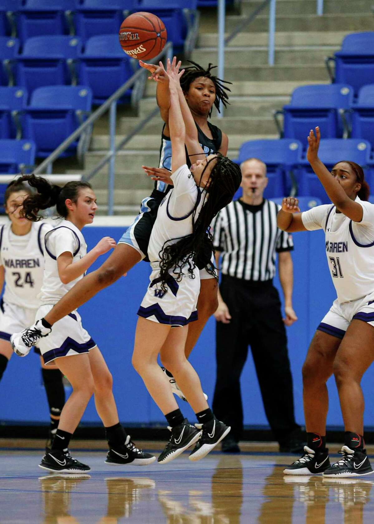 Harlan's Ariyel Gordon (30) makes a pass over Warren's Skye Stephens (12) during the first quarter of a conference game at Northside Gym in San Antonio, Texas, Saturday, Jan. 15, 2022. The Hawks defeated the Warriors 70-37.