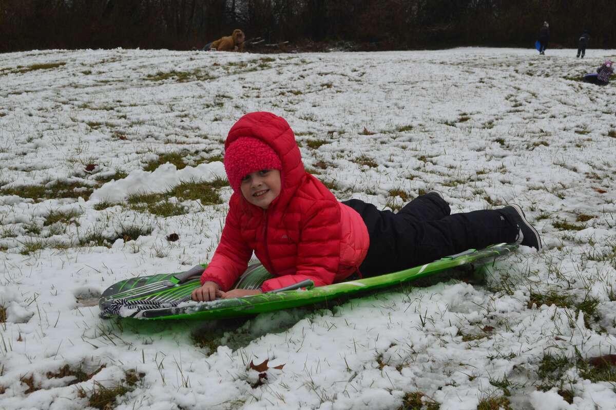 Evelyn Krag, 8, sledding at Miner Park on Saturday morning. Krag went to the park with her mother, Elizabeth, and was later surprised by a friend giving her an early birthday present. Krag turns 9 years old in the next few days. 
