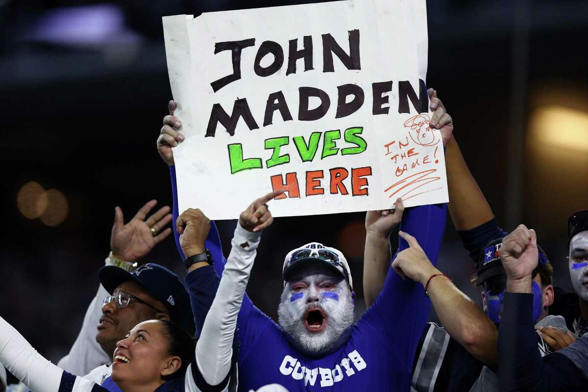 ARLINGTON, TEXAS - JANUARY 02: A Dallas Cowboys fan holds a sign honoring John Madden during the game against the Arizona Cardinals at AT&T Stadium on January 02, 2022 in Arlington, Texas. (Photo by Tom Pennington/Getty Images)
