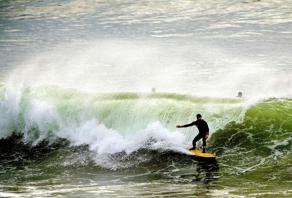 一名冲浪者在圣克鲁斯冲浪，尽管加州海滩沿岸有海啸危险的警告。