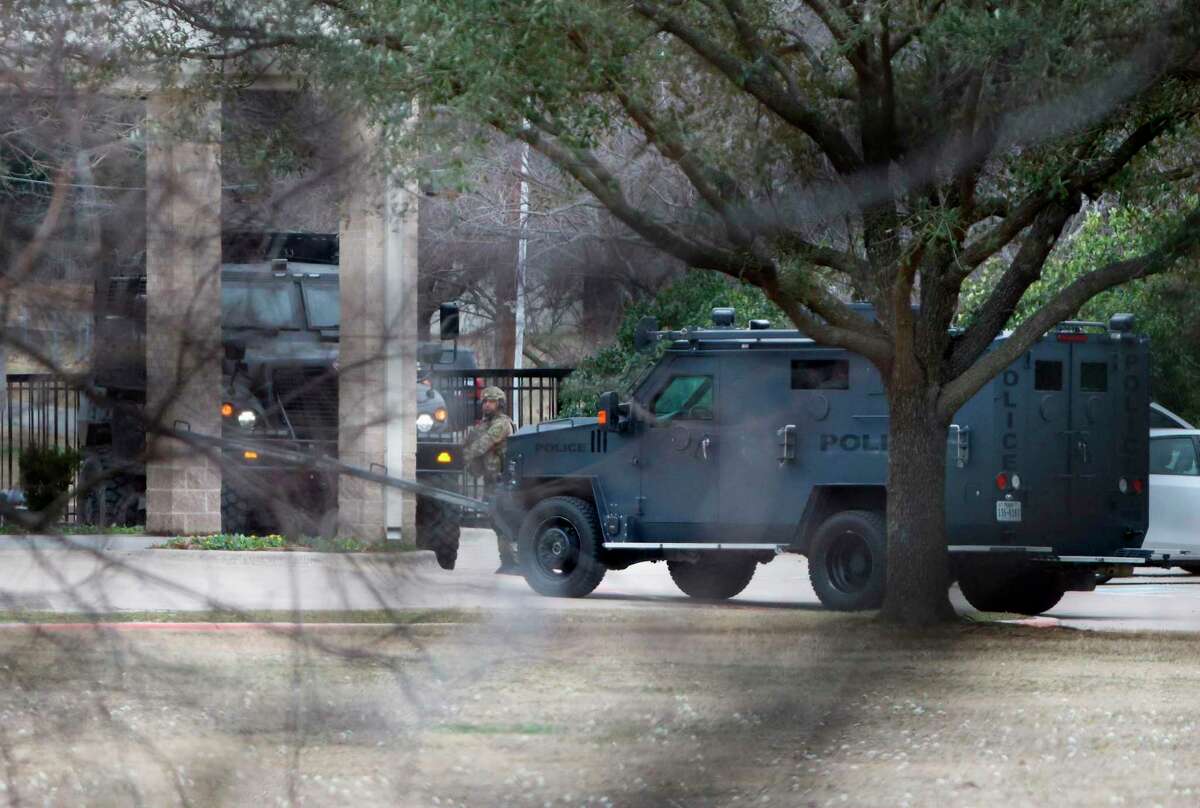 Law enforcement teams stage near Congregation Beth Israel while conducting SWAT operations in Colleyville, Texas on Saturday afternoon, Jan. 15, 2022. Authorities said a man took hostages Saturday during services at the synagogue where the suspect could be heard ranting in a livestream and demanding the release of a Pakistani neuroscientist who was convicted of trying to kill U.S. Army officers in Afghanistan.