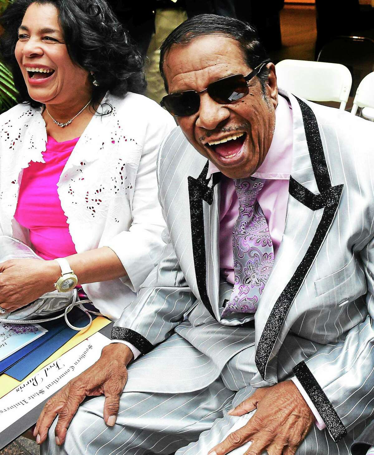 (Peter Hvizdak - New Haven Register) ¬ Fred Parris of Hamden, founder of New Haven's legendary New Doo-Wop group the Five Satins, right, and his wife Emma Parris, left, laugh with well-wishers aftertribute to him and the Five Satins at a City Hall ceremony Thursday, April 23, 2015 to commemorate the city's 377th birthday. Five commemorative trees along Church Street and Orange Street werededicated to honor the occasion. ¬