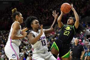 Oregon's Minyon Moore, right, shoots as UConn’s Olivia Nelson-Ododa, left, and Christyn Williams, center, defend in the second half on Feb. 3, 2020, in Storrs. UConn and Oregon meet again Monday in Eugene, Ore.