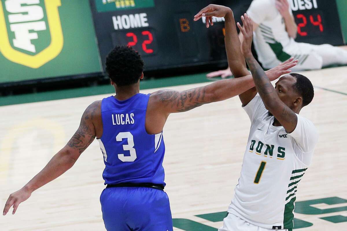 San Francisco Dons guard Jamaree Bouyea (1) scores a three-point shot while guarded by Brigham Young Cougars guard Te'Jon Lucas (3) in the first half of an NCAA men’s basketball game at Memorial Gym, Saturday, Jan. 15, 2022, in San Francisco, Calif.