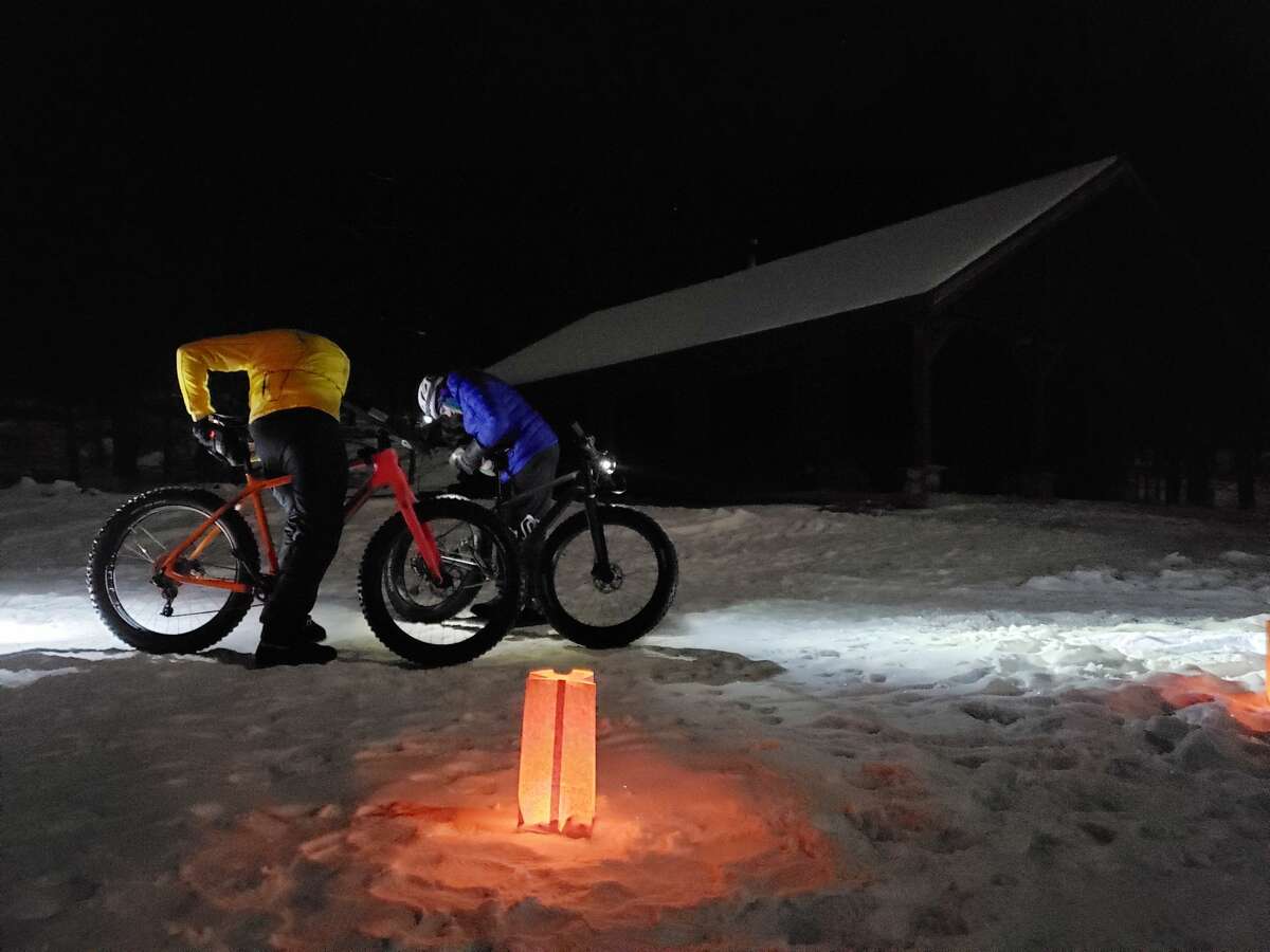 Wayne Stroope and Sue Stroope gear up for a fat tire bike run through Big M's trail system on Saturday during a moonlight winter sporting gathering. 