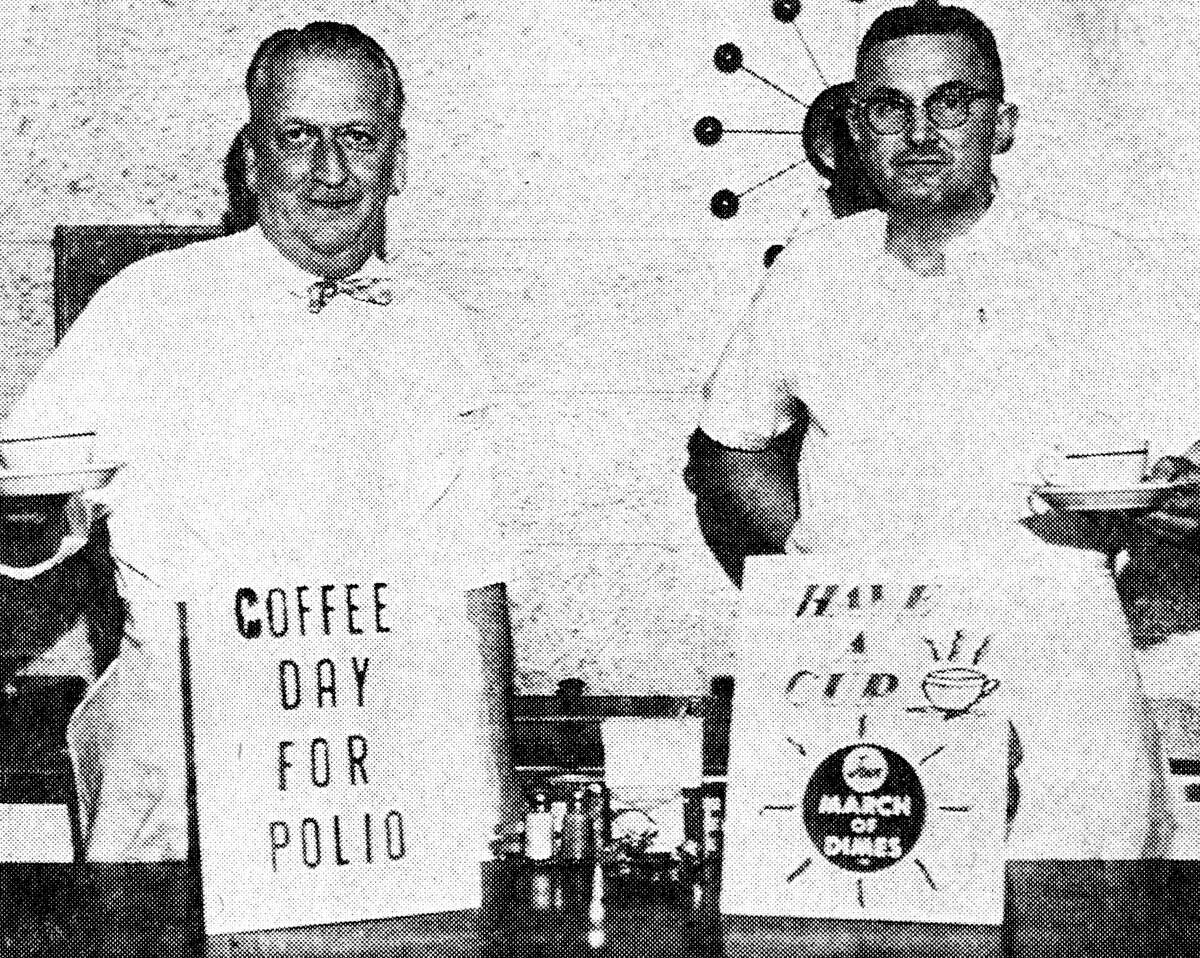 Tomorrow is Coffee Day for the March of Dimes in Manistee. (From left) Bill Hansen and Erwin Rhodea, co-chairmen of the projects, show the way to increase the March of Dimes fund by drinking coffee and depositing their money in the various eating establishments throughout Manistee. The photo was published in the News Advocate on Jan. 18, 1962.