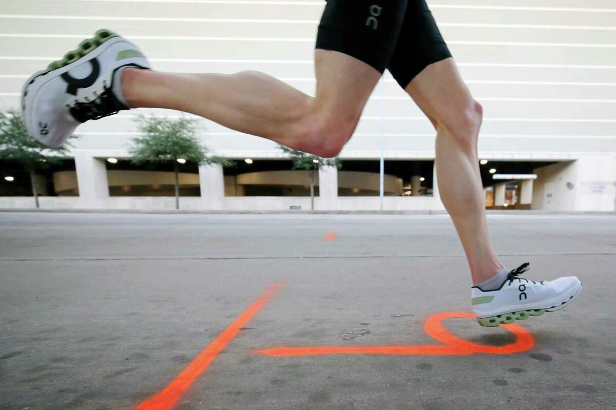 Runners pass the nine mile marker on Main St. during the Chevron Houston Marathon Sunday, Jan. 16, 2022 in Houston, TX.