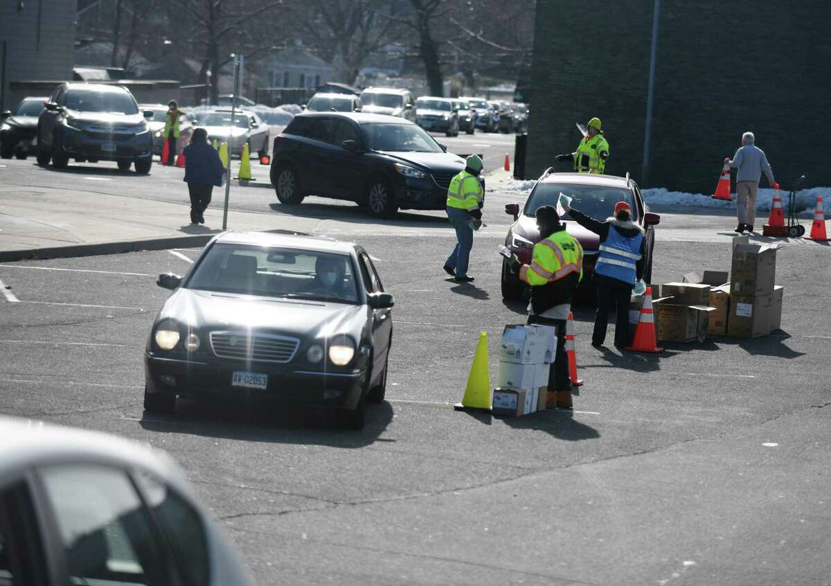 Masks are distributed at AITE High School in Stamford, Conn. Sunday, Jan. 16, 2022. 2,500 five-packs of N95 masks and 2,500 five-packs of surgical masks were distributed to Stamford residents in a drive-thru and walk-up fashion on Sunday.