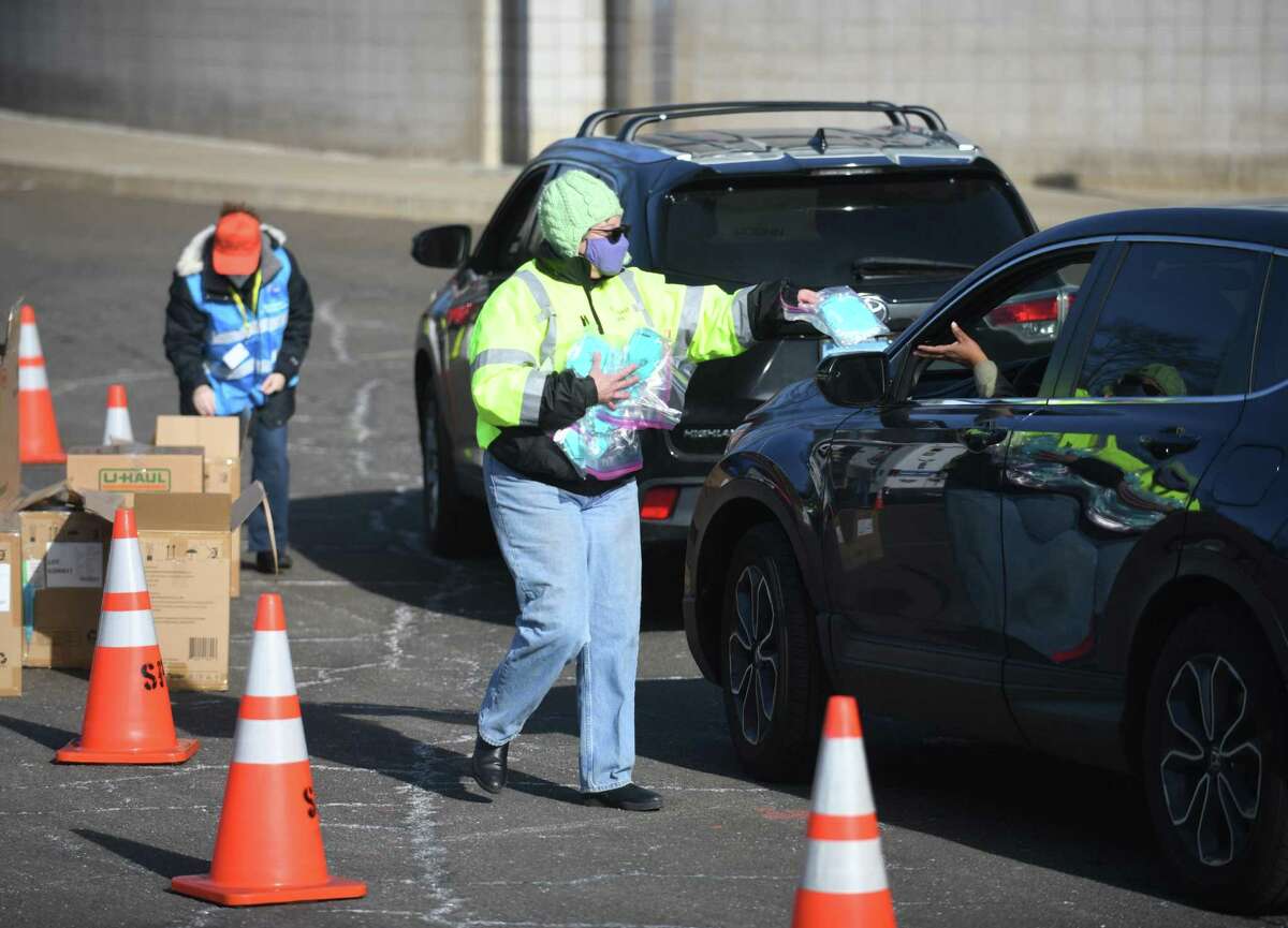 Masks are distributed at AITE High School in Stamford, Conn. Sunday, Jan. 16, 2022. 2,500 five-packs of N95 masks and 2,500 five-packs of surgical masks were distributed to Stamford residents in a drive-thru and walk-up fashion on Sunday.