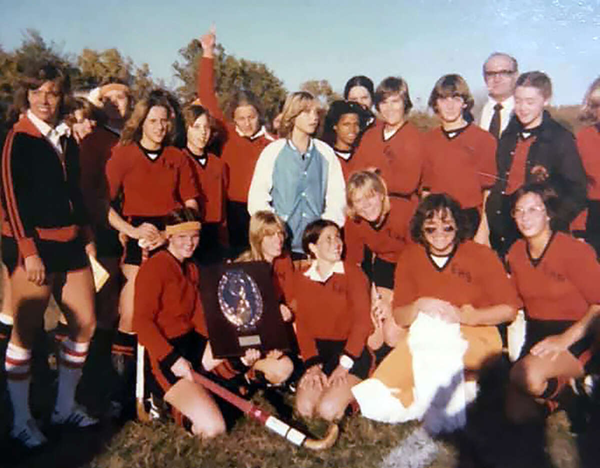 Debbie (Seybert) Romero, front row second from left, and the Edwardsville field hockey team pose with the championship plaque after beating Mascoutah to win the sectional at SIUE.