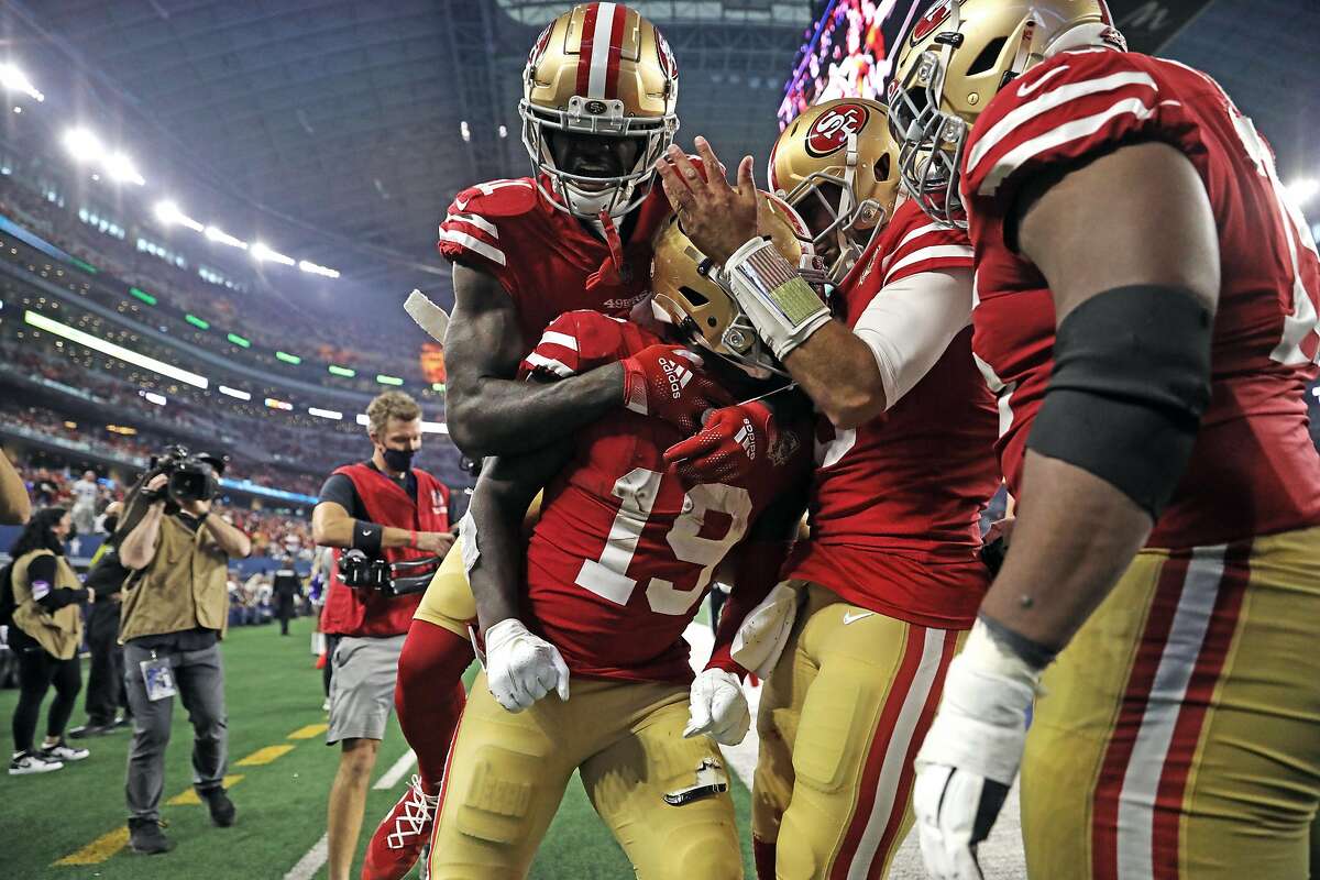 The 49ers’ Deebo Samuel celebrates his 26-yard touchdown run with Brandon Ayuk and Jimmy Garoppolo in the 3rd quarter against the Cowboys during their NFC Wild Card game at AT&T Stadium in Arlington, Texas.