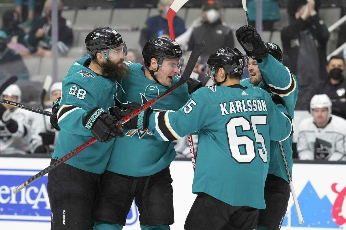 San Jose Sharks right wing Timo Meier celebrates with defensemen Brent Burns (88) and Erik Karlsson (65) and center Tomas Hertl after scoring a goal during the first period against the Los Angeles Kings during an NHL hockey game in San Jose, Calif., Monday, Jan. 17, 2022. (AP Photo/Darren Yamashita)