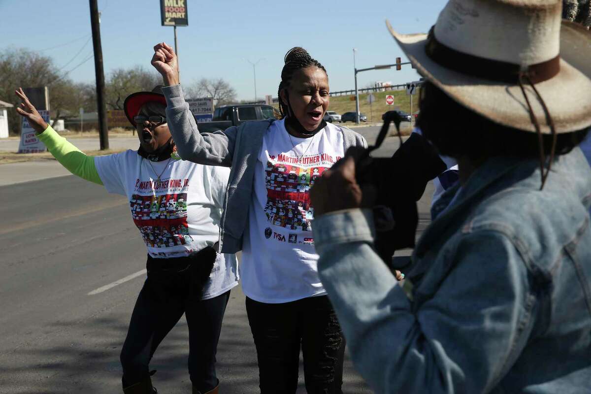 Volunteers, including, Ann Flowers, center, dance to the music as they participate in the Martin Luther King Freedom March along MLK Boulevard on Monday. A small group of around 70 marched from Pittman-Sullivan Park to Martin Luther King Park. The official march, which draws hundreds of thousands, was canceled due to COVID-19. It is the second year the march has been canceled.