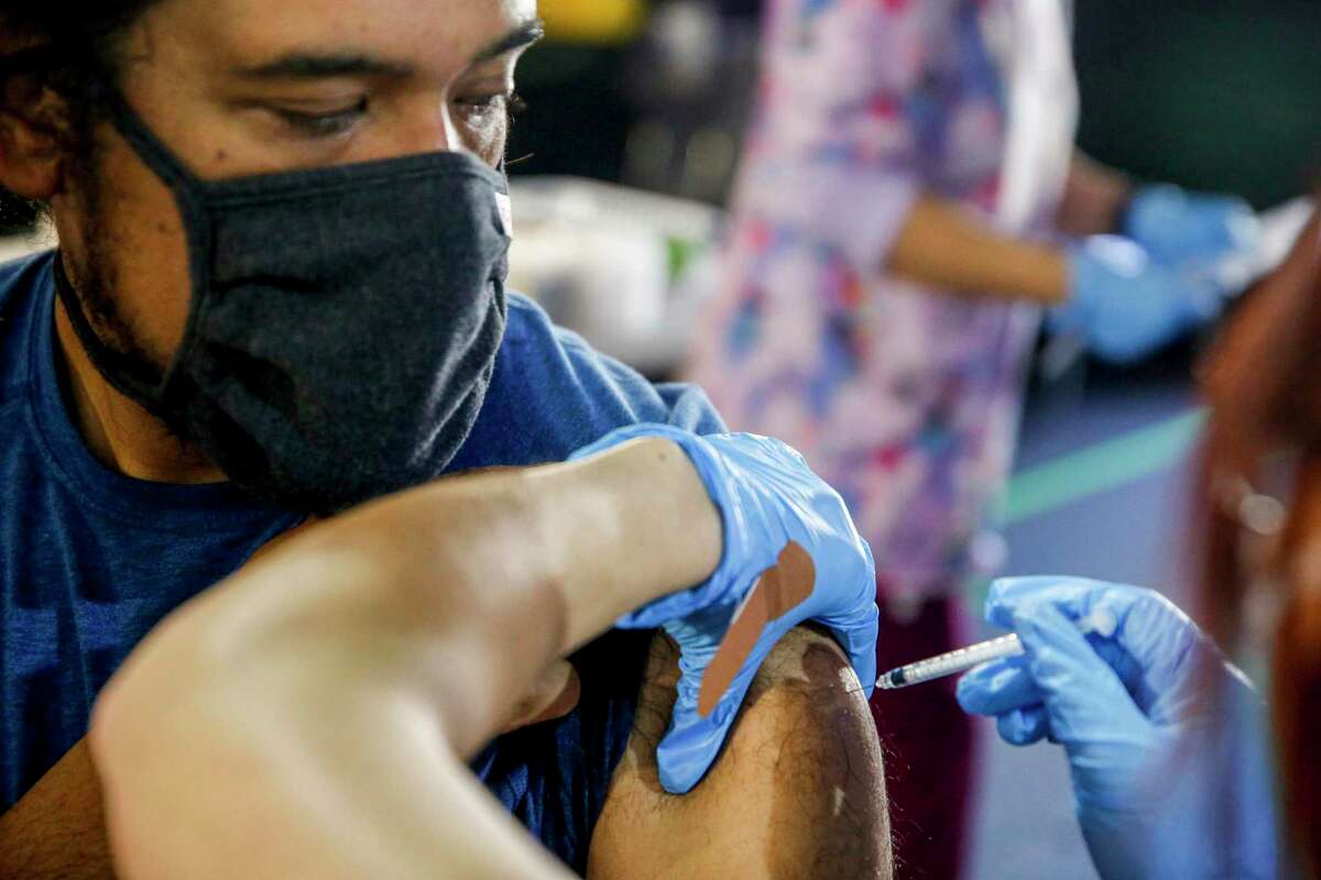 Armando Vera receives his booster shot during a vaccination clinic held by the Santa Clara County Public Health Department at Children’s Discovery Museum in San Jose this month. The Bay Area’s high vaccination rate is helping combat the omnicron surge.