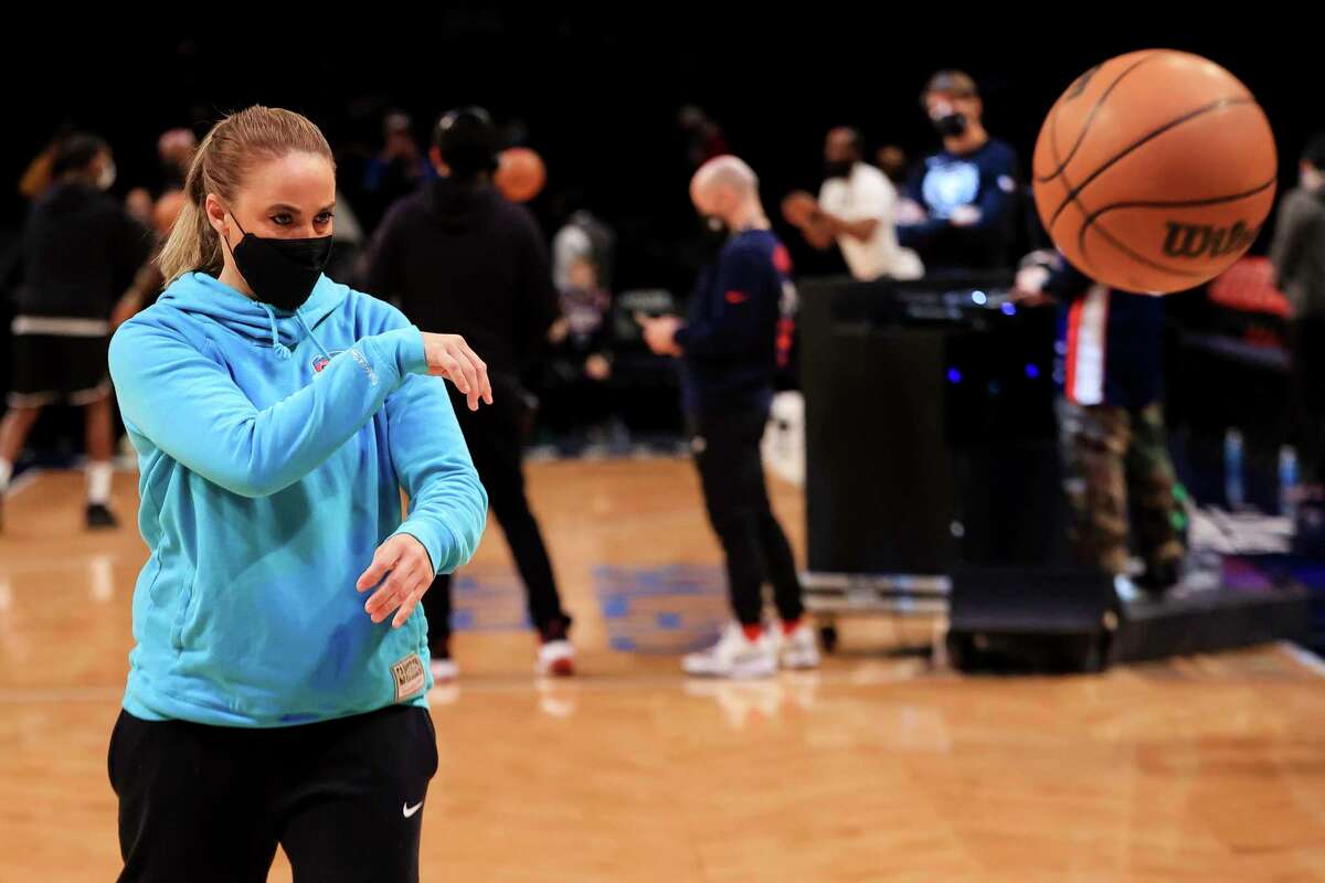 San Antonio Spurs coach Becky Hammon passes to a member of the Spurs before the start an NBA basketball game against the Brooklyn Nets, Sunday, Jan. 9, 2022, in New York.