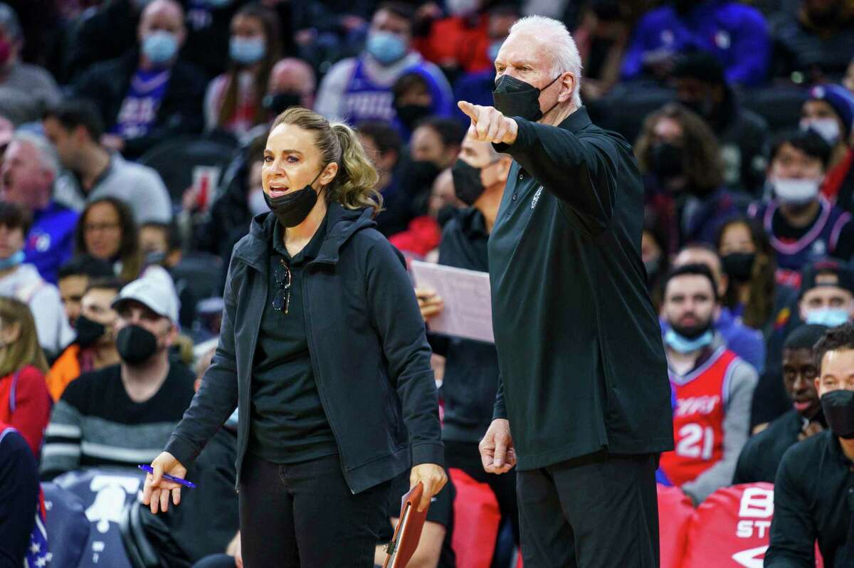 San Antonio Spurs head coach Gregg Popovich, right, directs his team with assistant coach Becky Hammon, left, looking on during the first half of an NBA basketball game against the Philadelphia 76ers, Friday, Jan. 7, 2022, in Philadelphia. The 76ers won 119-100.