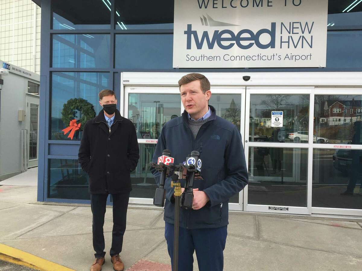 Tweed New Haven Airport Authority Executive Director Sean Scanlon, right, joined by Mayor Justin Elicker, left, speaks after riding the CT Transit 206 bus to Tweed New Haven Regional Airport on Wednesday, Dec. 15, 2021.