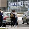 Students hug at outside Oxford High School in Oxford, Mich., Wednesday, Dec. 1, 2021. Authorities say a 15-year-old sophomore opened fire at Oxford High School, killing four students and wounding seven other people on Tuesday. (AP Photo/Paul Sancya)