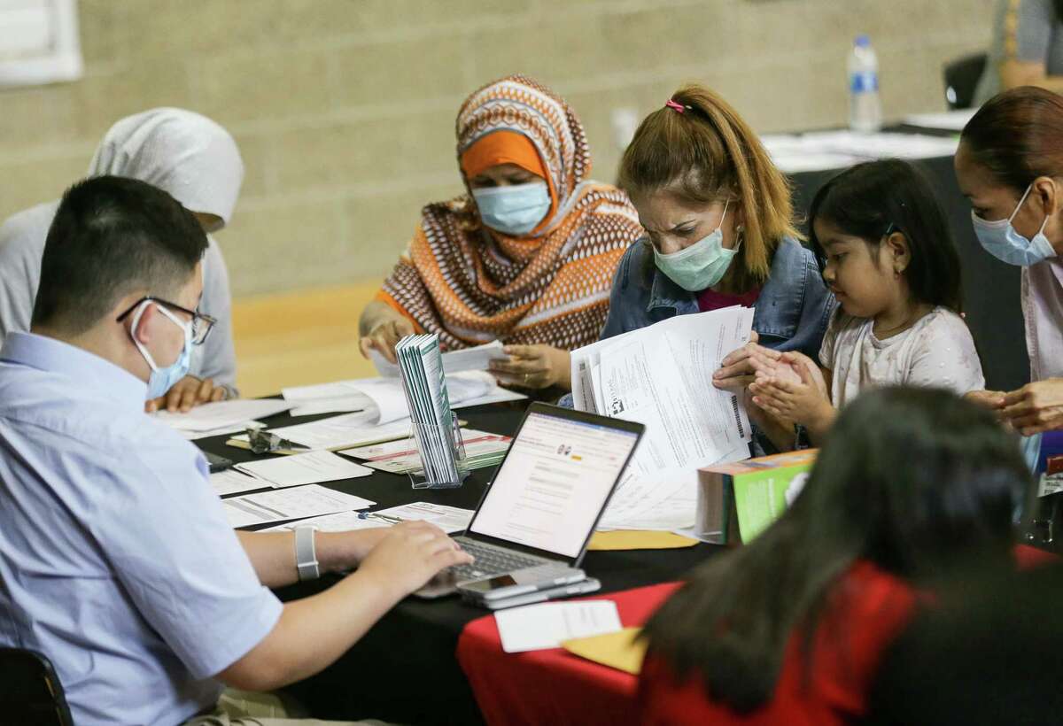 People fill out the application for the Emergency Rental Assistance program at the Baker Ripley Gulfton-Sharpstown in July 2021. The U.S. Department of the Treasury has begun reallocating aid from programs that were slow to distribute aid to those that were faster, like Houston and Harris County’s.