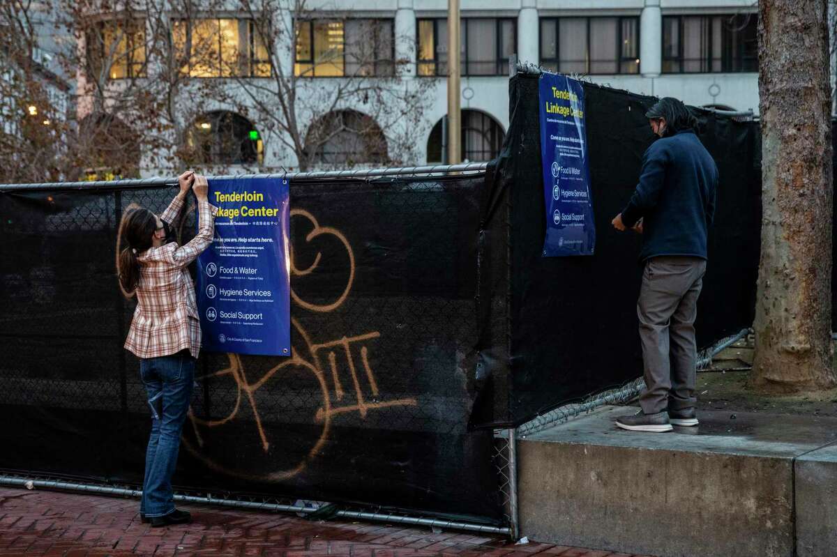 City workers install signage outside the Tenderloin Linkage Center at United Nations Plaza before its opening in San Francisco in January.  The center provides people on the streets with treatment, housing and resources.