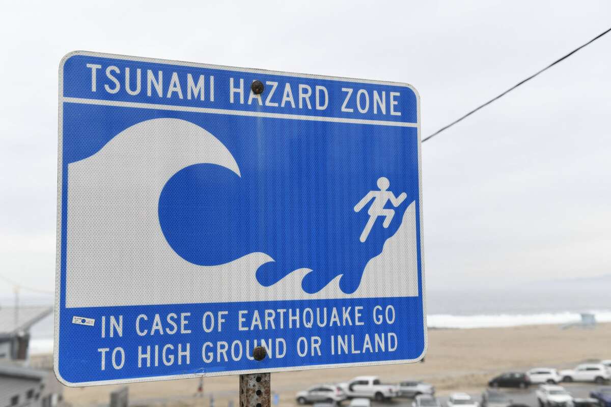 A tsunami hazard zone sign is displayed near a beach in El Segundo, Calif.