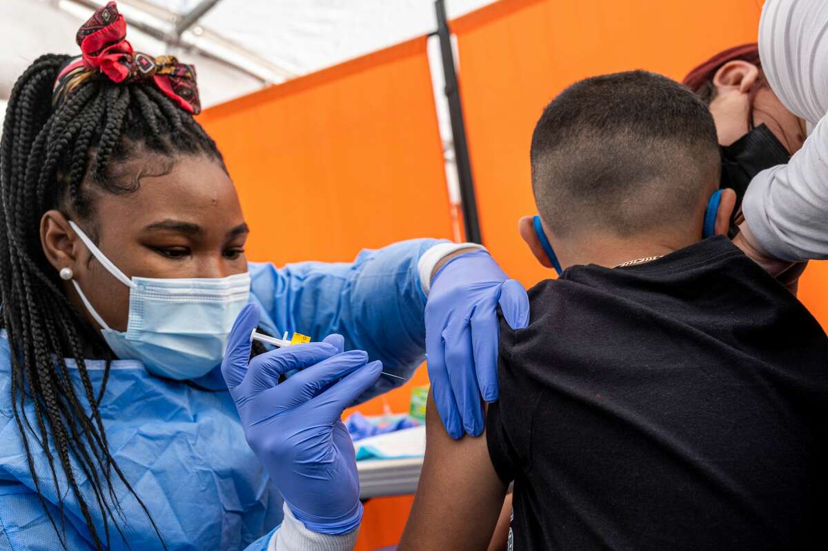 A health care worker administers a Pfizer-BioNTech COVID-19 vaccine to a child at a testing and vaccination site in San Francisco on Jan. 10, 2022.