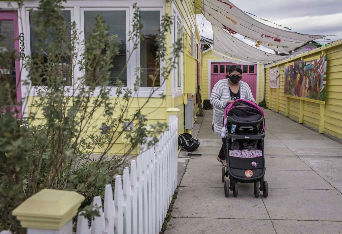 Maria Vega walks home with her 9-month-old daughter following a visit to the Ayudando Latinos A Soñar building in Half Moon Bay. Vega quit her job as a fast-food worker two months after learning she was pregnant. A new Sutter Health study of 17,000 pregnant women showed that living with multiple people and working around people increased the chances of contracting COVID-19 while pregnant.