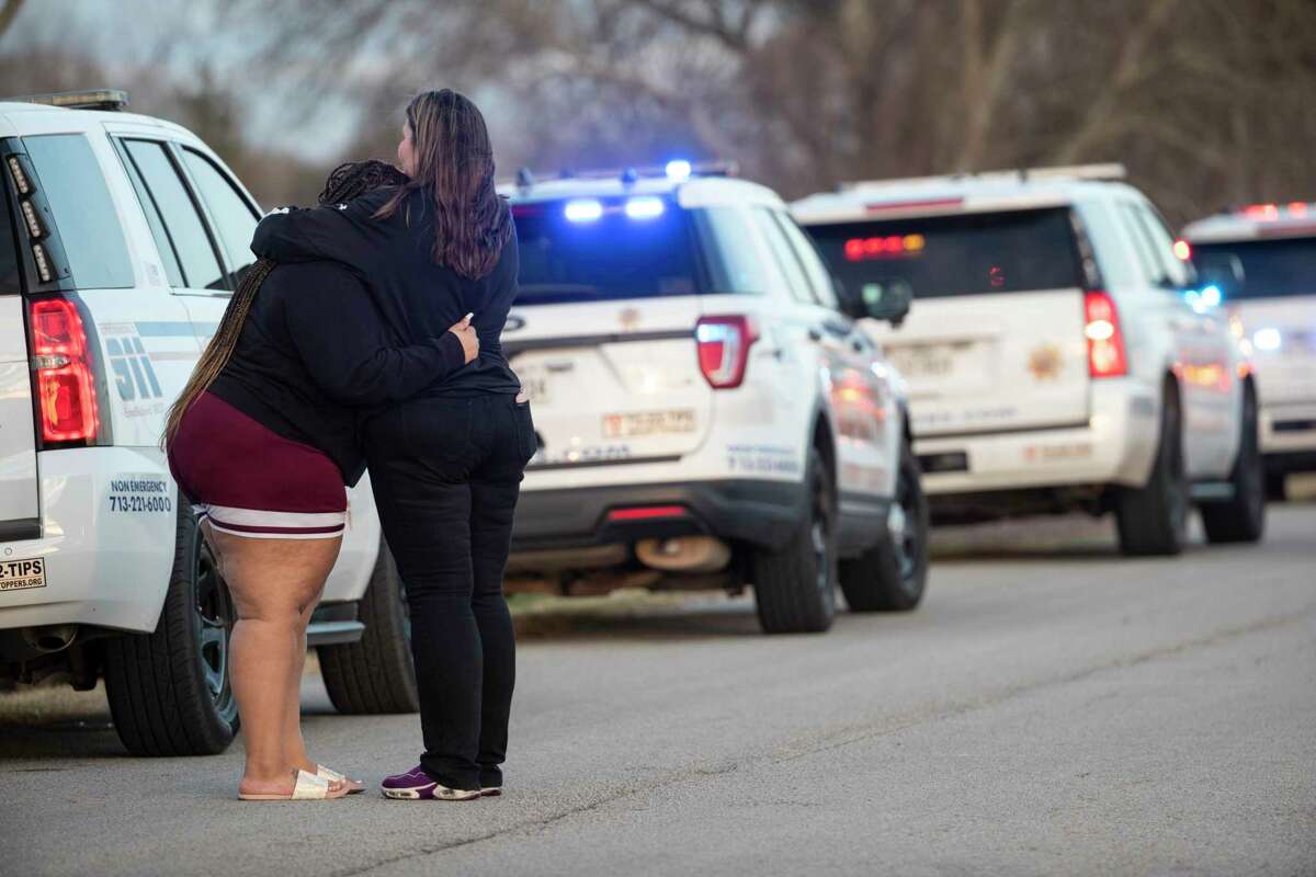 A pair of women embrace as sheriff’s officers investigate the scene where the bodies of three teenagers were found dead inside of a home Tuesday, Jan. 18, 2022 in Crosby. Sherff Ed Gonzalez said that there were two female and one male victim in an apparent murder, suicide.
