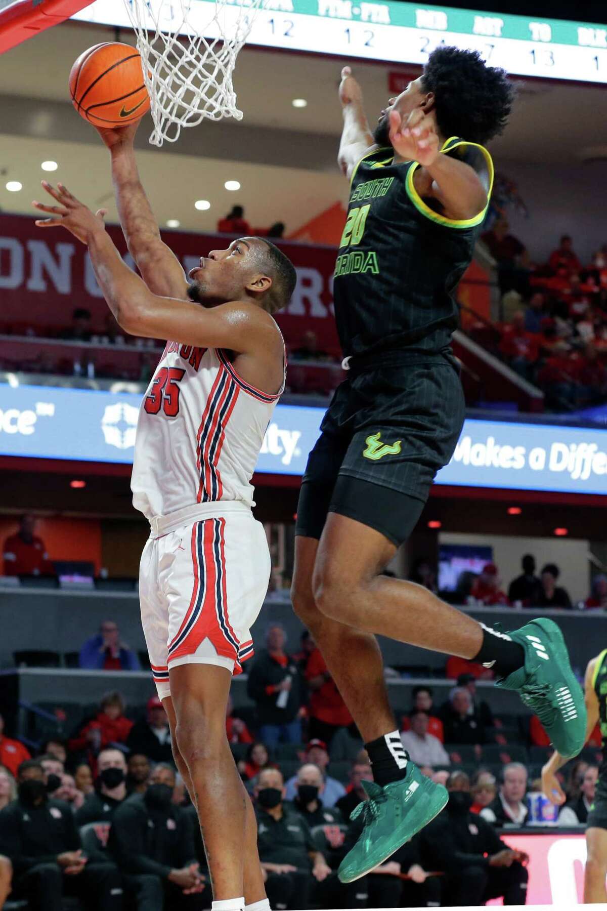 Houston forward Fabian White Jr. (35) puts up a shot in front of South Florida forward Sam Hines Jr. (20) during the second half of a NCAA basketball game Tuesday, Jan. 18, 2022 in Houston, TX.