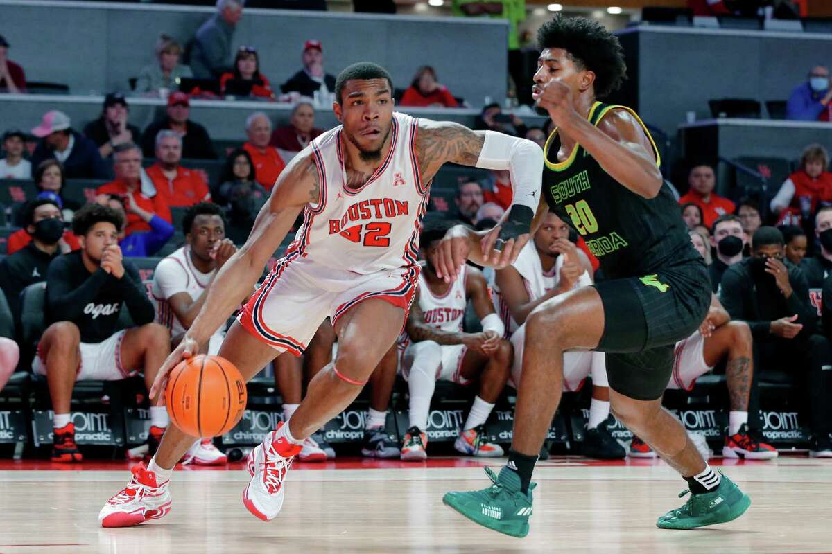 Houston forward Reggie Chaney (32) drives around South Florida forward Sam Hines Jr. (20) during the second half of a NCAA basketball game Tuesday, Jan. 18, 2022 in Houston, TX.