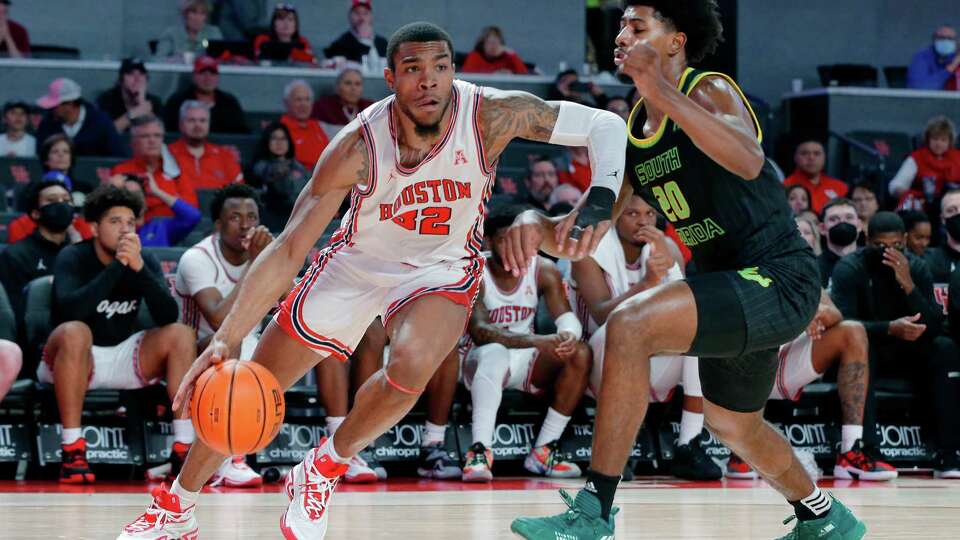 Houston forward Reggie Chaney (32) drives around South Florida forward Sam Hines Jr. (20) during the second half of a NCAA basketball game Tuesday, Jan. 18, 2022 in Houston, TX.