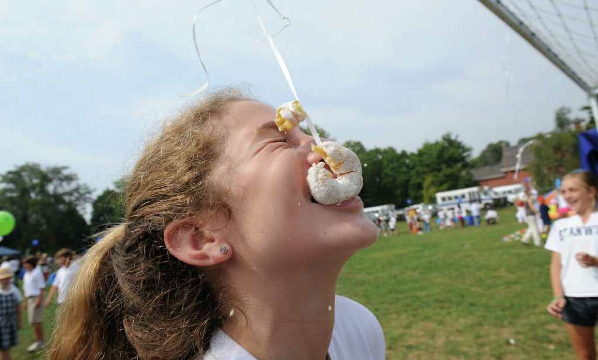 Hannah Karlan, 13 of Greenwich, plays the donut eating game at the 2nd Annual Stanwich Family Festival at the Stamford campus in Stamford, Conn. on Friday September 24, 2010