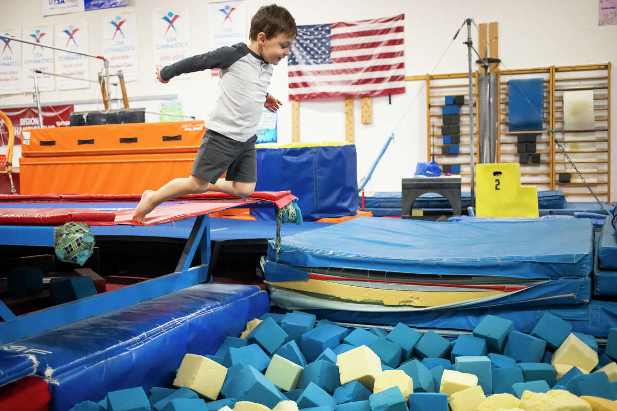 William Schefsky, 3, leaps into a foam pit Wednesday, Jan. 19, 2022 during a weekly Preschool Playtime session at Midland Gymnastics Training Center.