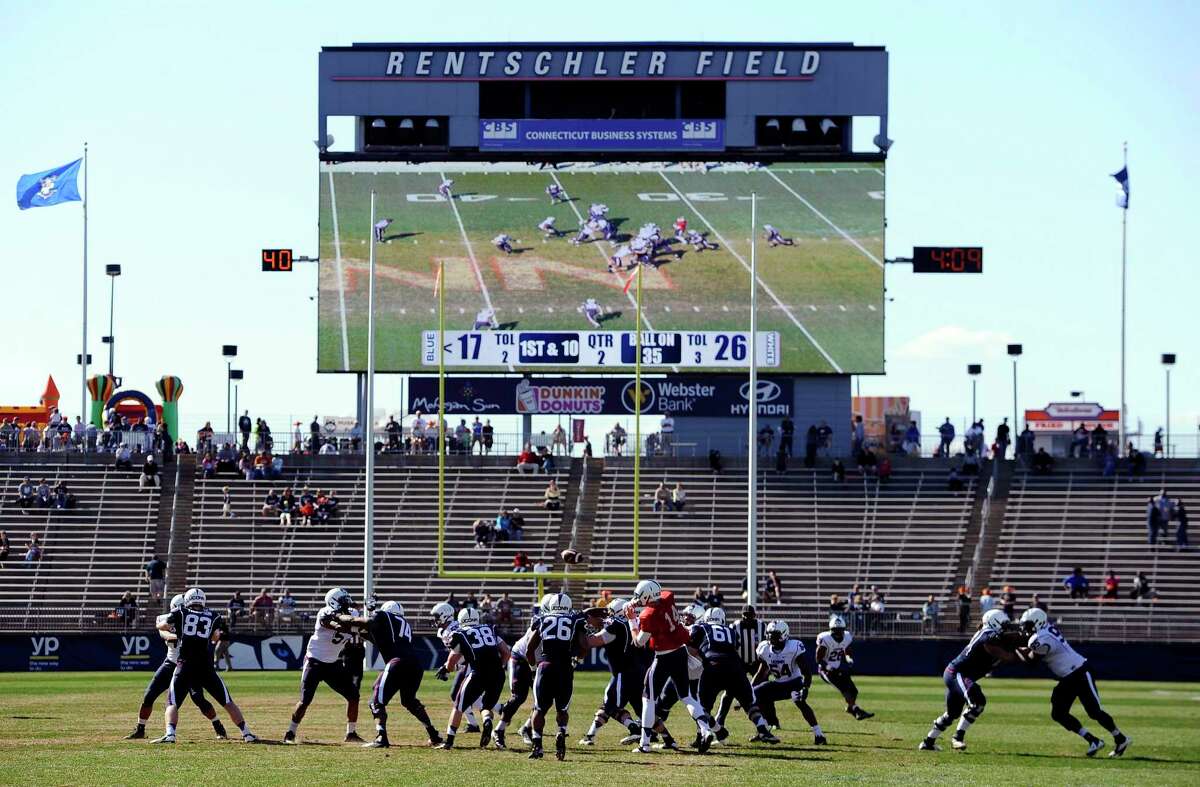 In this April 12, 2014, file photo Connecticut players run a play during the first half of UConn's Blue-White spring NCAA college football game at Rentschler Field, in East Hartford.